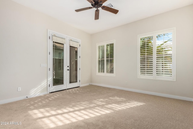 carpeted empty room featuring ceiling fan and french doors