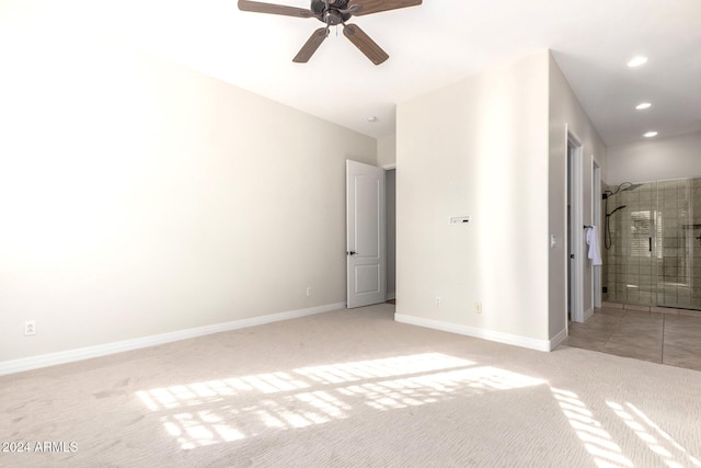 unfurnished bedroom featuring connected bathroom, light carpet, and ceiling fan