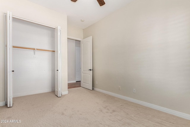 unfurnished bedroom featuring light carpet, ceiling fan, and a closet