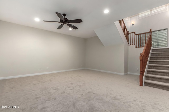 unfurnished living room featuring ceiling fan and light carpet