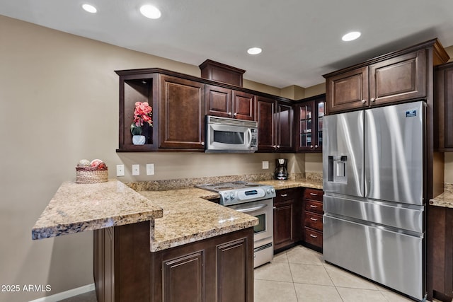4200 N Miller Rd Unit 408, Scottsdale, AZ 85251 - kitchen featuring stainless steel appliances, a peninsula, dark brown cabinetry, glass insert cabinets, and light tile patterned floors