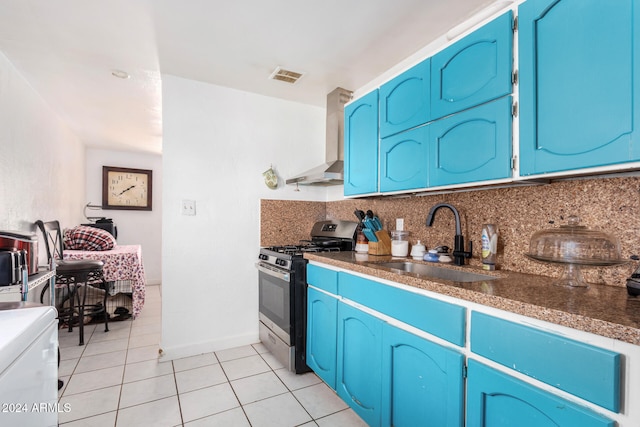 kitchen featuring tasteful backsplash, blue cabinets, sink, light tile patterned floors, and stainless steel range with gas stovetop