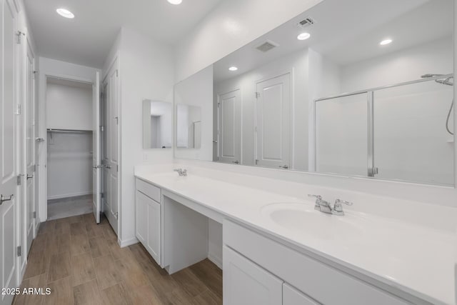 bathroom with vanity and a shower with door