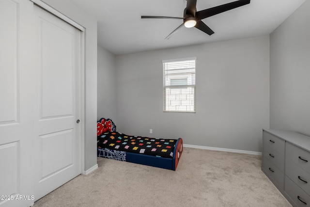 carpeted bedroom with ceiling fan and a closet