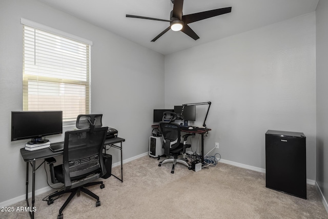 carpeted home office featuring ceiling fan