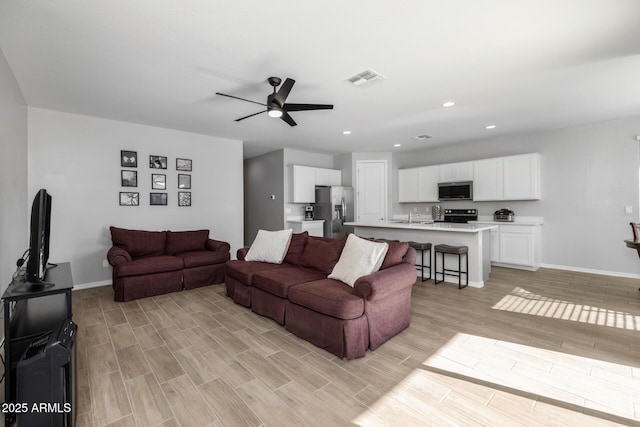 living room with ceiling fan and sink