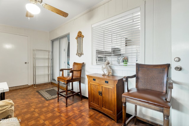 sitting room featuring ceiling fan and dark parquet flooring