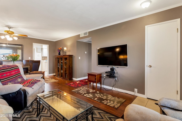 living room featuring ceiling fan, ornamental molding, and light hardwood / wood-style floors