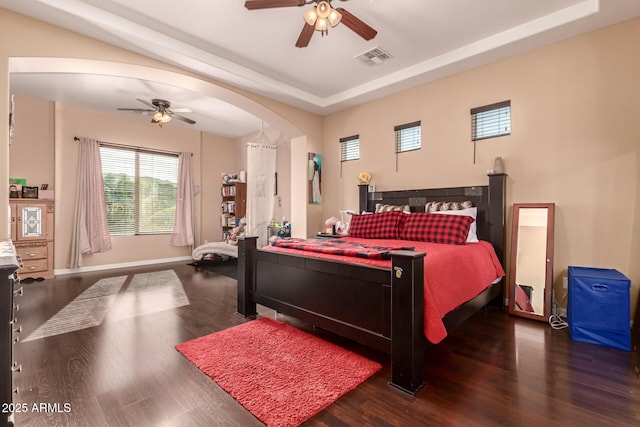 bedroom featuring a raised ceiling, ceiling fan, and dark hardwood / wood-style floors