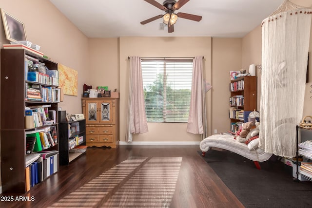 sitting room featuring ceiling fan and dark wood-type flooring