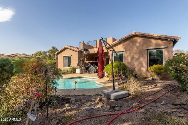 rear view of property featuring a balcony and a patio