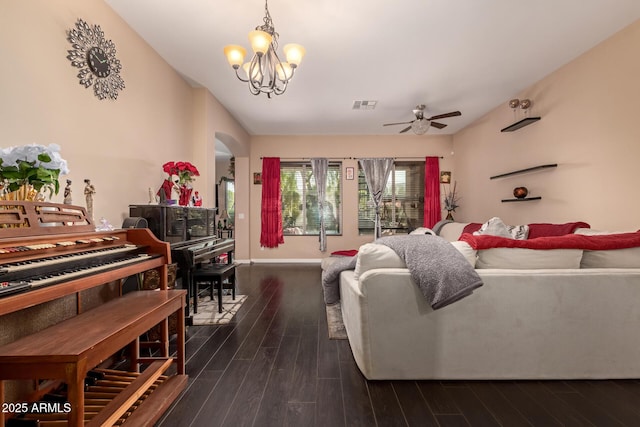 living room with ceiling fan with notable chandelier and dark wood-type flooring