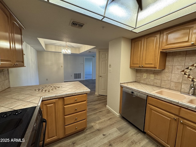 kitchen with light wood finished floors, a chandelier, tile countertops, dishwasher, and electric stove