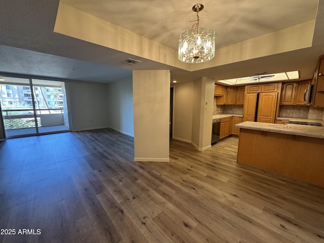 interior space with visible vents, open floor plan, appliances with stainless steel finishes, decorative backsplash, and a raised ceiling