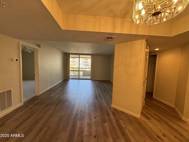 spare room featuring visible vents and dark wood-type flooring