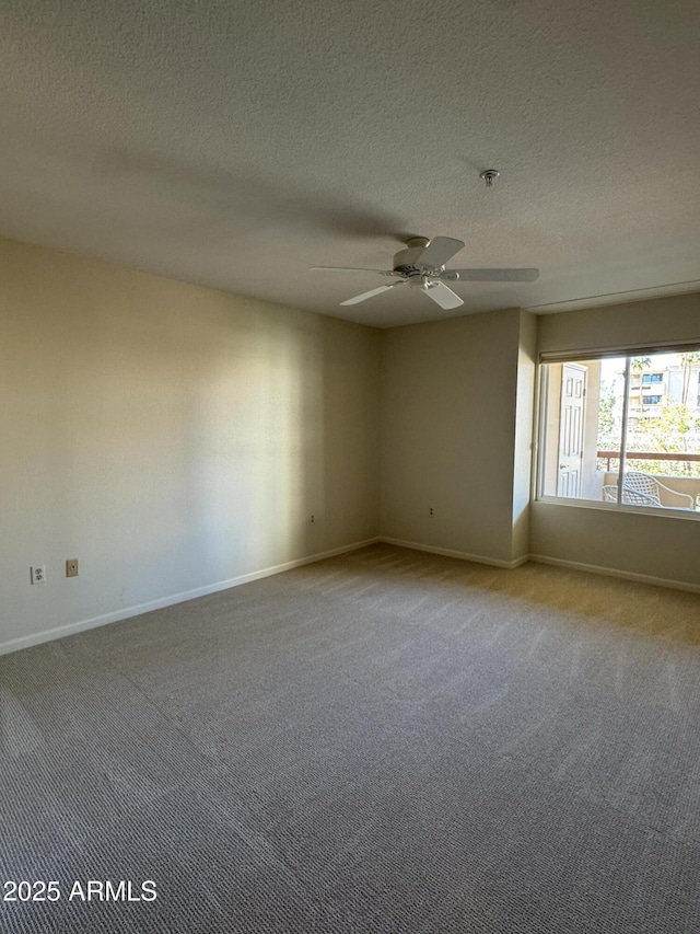 carpeted spare room featuring a textured ceiling, baseboards, and ceiling fan