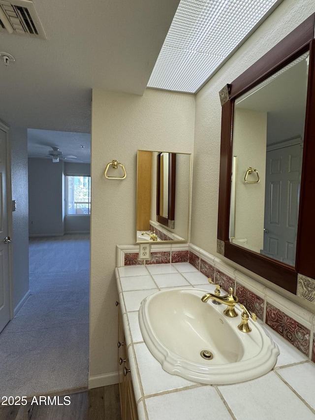 bathroom featuring visible vents, ceiling fan, and vanity