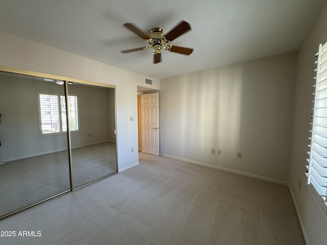 unfurnished bedroom featuring visible vents, a closet, carpet flooring, baseboards, and ceiling fan