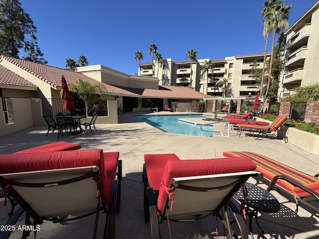 community pool with fence and a patio area