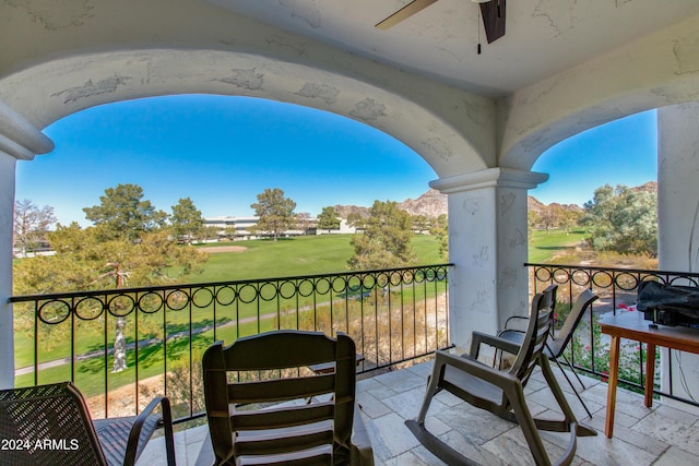 balcony featuring view of golf course and ceiling fan