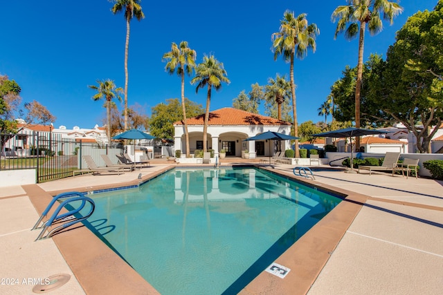 community pool featuring a patio and fence