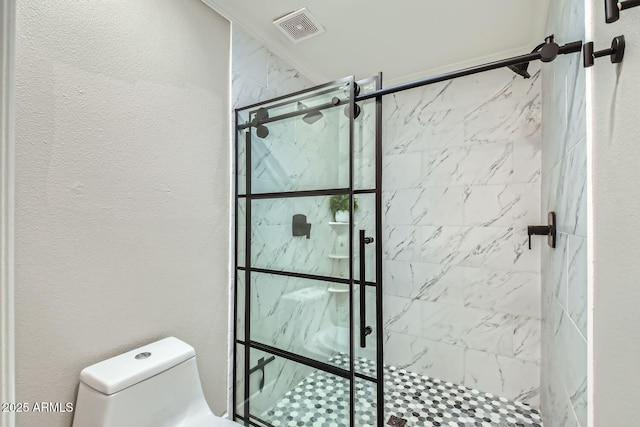 bathroom with a tile shower and toilet