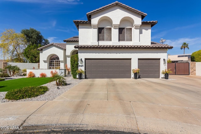 mediterranean / spanish-style house with a garage, driveway, a tile roof, and stucco siding