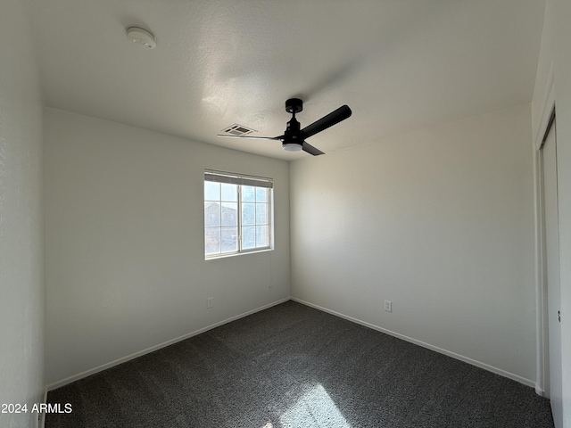 carpeted spare room with ceiling fan