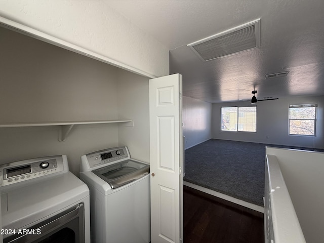 laundry area with independent washer and dryer and a textured ceiling