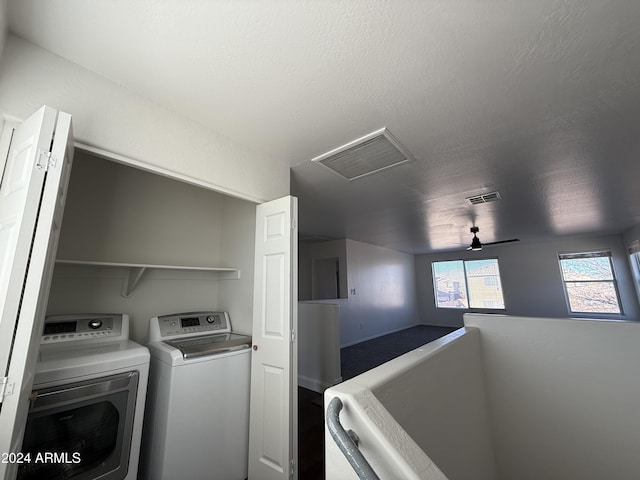 laundry area featuring washing machine and clothes dryer and a textured ceiling