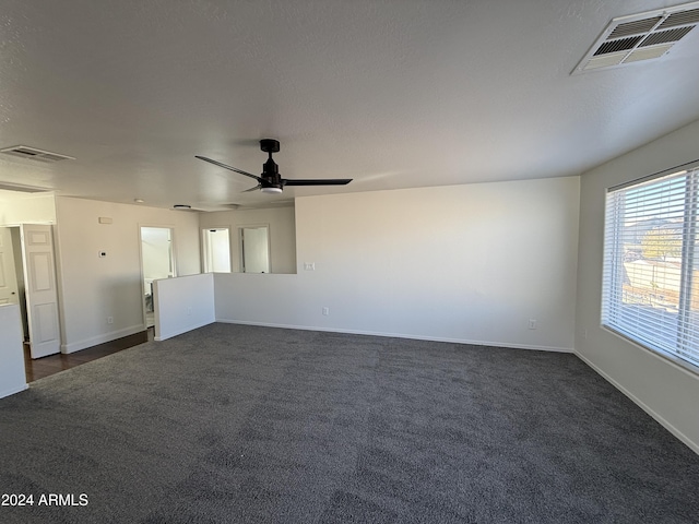 empty room with dark carpet and ceiling fan