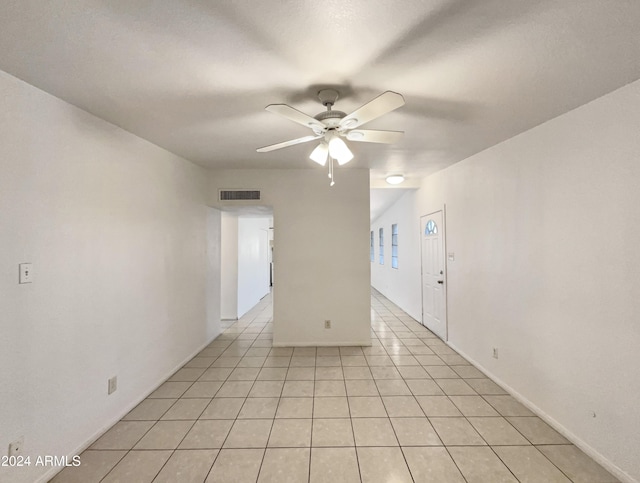 empty room with ceiling fan and light tile patterned flooring