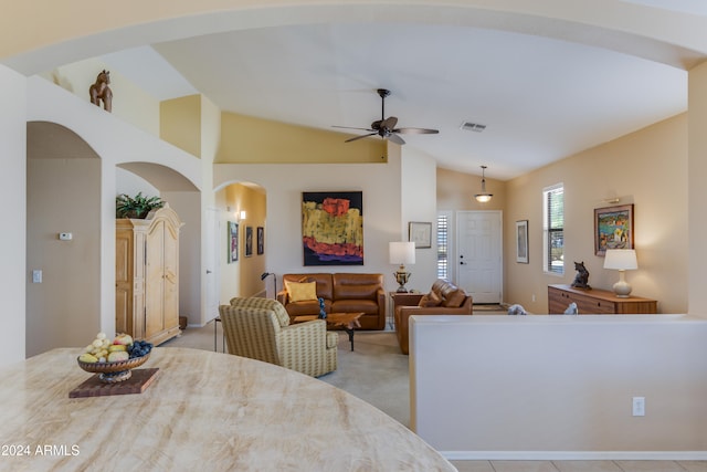 tiled dining area with ceiling fan and lofted ceiling