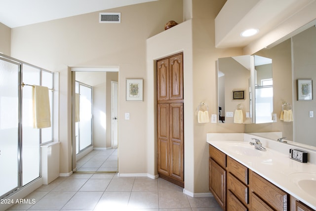 bathroom with tile patterned floors, vanity, vaulted ceiling, and walk in shower