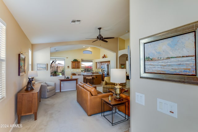 carpeted living room with vaulted ceiling and ceiling fan