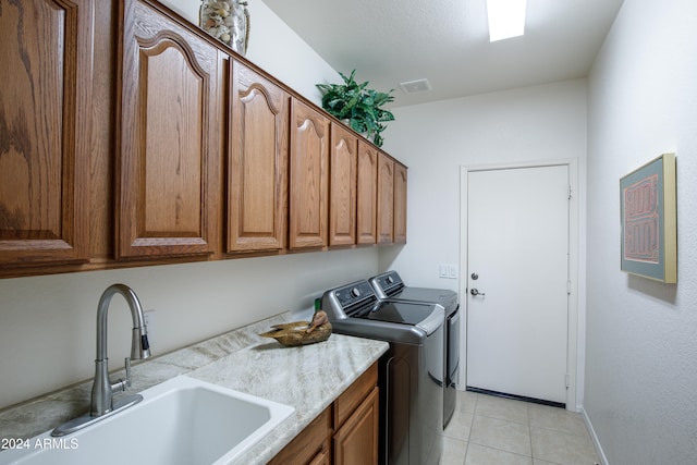 laundry area with cabinets, sink, light tile patterned floors, and washer and dryer