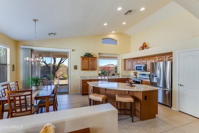 kitchen with a center island, lofted ceiling, sink, a notable chandelier, and stainless steel appliances