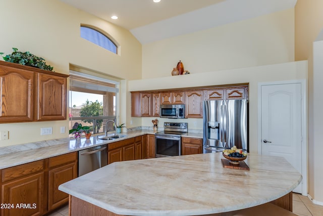 kitchen featuring sink, a center island, high vaulted ceiling, light tile patterned floors, and appliances with stainless steel finishes