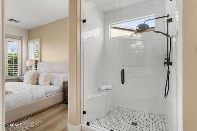 bathroom with a stall shower, ensuite bath, visible vents, and wood finished floors