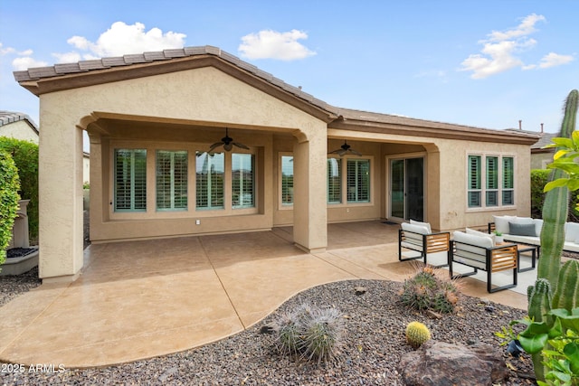 back of house with a patio area, ceiling fan, an outdoor living space, and stucco siding