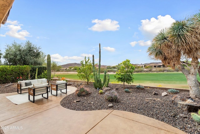 view of home's community with a mountain view, a patio, an outdoor living space, and a lawn