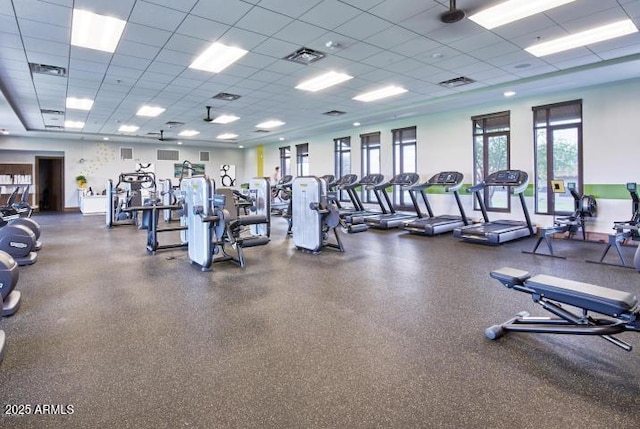 exercise room with a paneled ceiling and visible vents