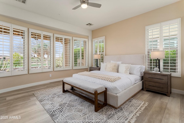 bedroom with baseboards, a ceiling fan, visible vents, and light wood-style floors