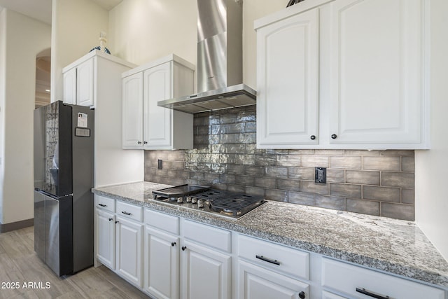 4915 N Greentree Dr, Litchfield Park, AZ 85340 - kitchen with wall chimney range hood, decorative backsplash, white cabinets, and appliances with stainless steel finishes