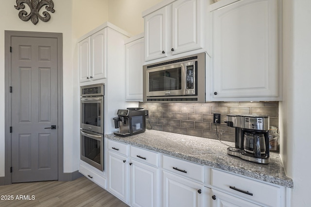 4915 N Greentree Dr, Litchfield Park, AZ 85340 - kitchen with stainless steel appliances, white cabinetry, tasteful backsplash, and stone counters