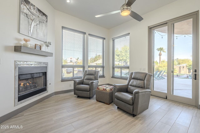 4915 N Greentree Dr, Litchfield Park, AZ 85340 - living area with ceiling fan, a wealth of natural light, a high end fireplace, and light hardwood / wood-style floors