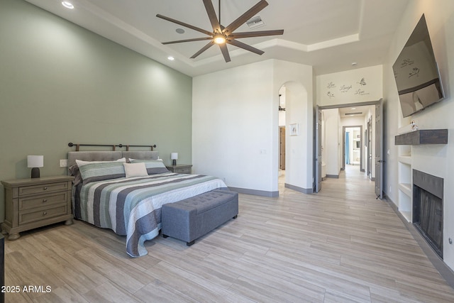 4915 N Greentree Dr, Litchfield Park, AZ 85340 - bedroom featuring a tray ceiling, a towering ceiling, ceiling fan, and light wood-type flooring