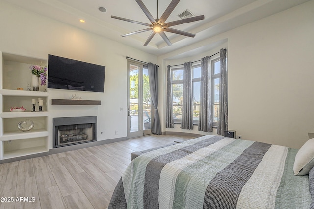 4915 N Greentree Dr, Litchfield Park, AZ 85340 - bedroom with ceiling fan, a tray ceiling, access to exterior, and light wood-type flooring