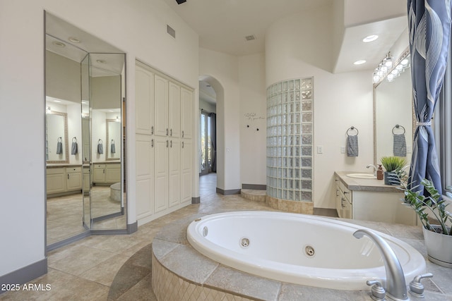 4915 N Greentree Dr, Litchfield Park, AZ 85340 - bathroom with vanity, a relaxing tiled tub, and tile patterned floors