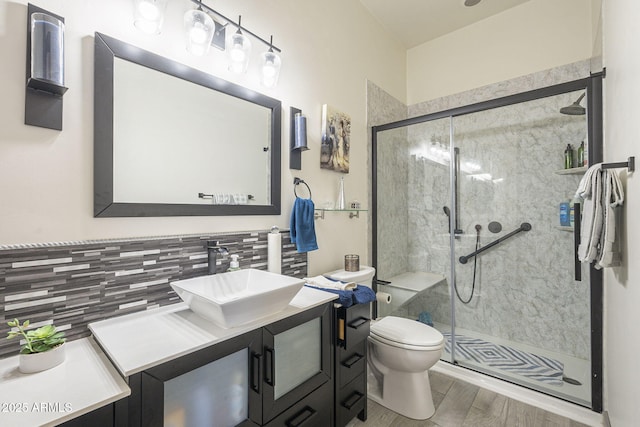 4915 N Greentree Dr, Litchfield Park, AZ 85340 - bathroom featuring hardwood / wood-style floors, vanity, decorative backsplash, a shower with shower door, and toilet